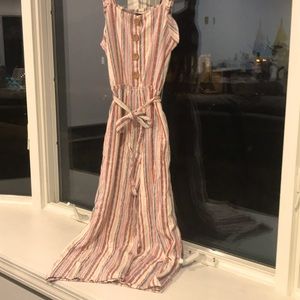 Cream colored jumpsuit with pastel colored stripes, oak buttons and a cloth tie